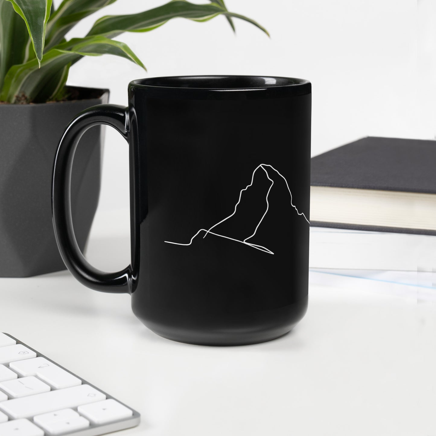 Black glossy minimalist mug with line art design, featuring a handle on the left, by Knot Qualified.