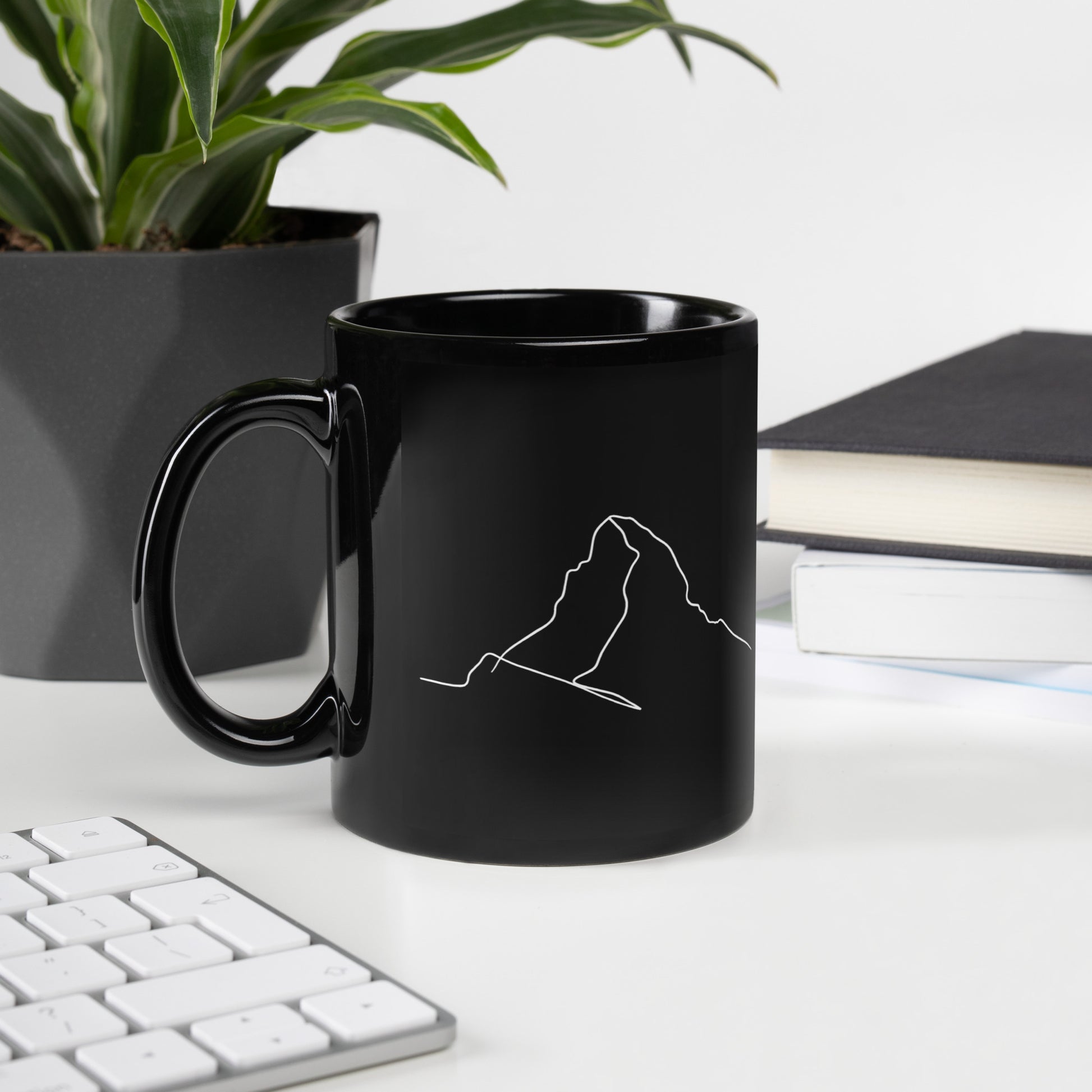 Black glossy Matterhorn minimalist line art mug with a handle on the left, perfect for coffee lovers.
